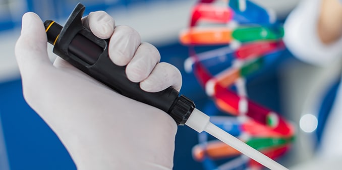 cropped view of geneticist holding micropipette and pointing with finger on blurred background, banner